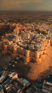 Breathtaking aerial view of the historic Jaisalmer Fort in Rajasthan, India at sunset. A golden monument in the Thar Desert.